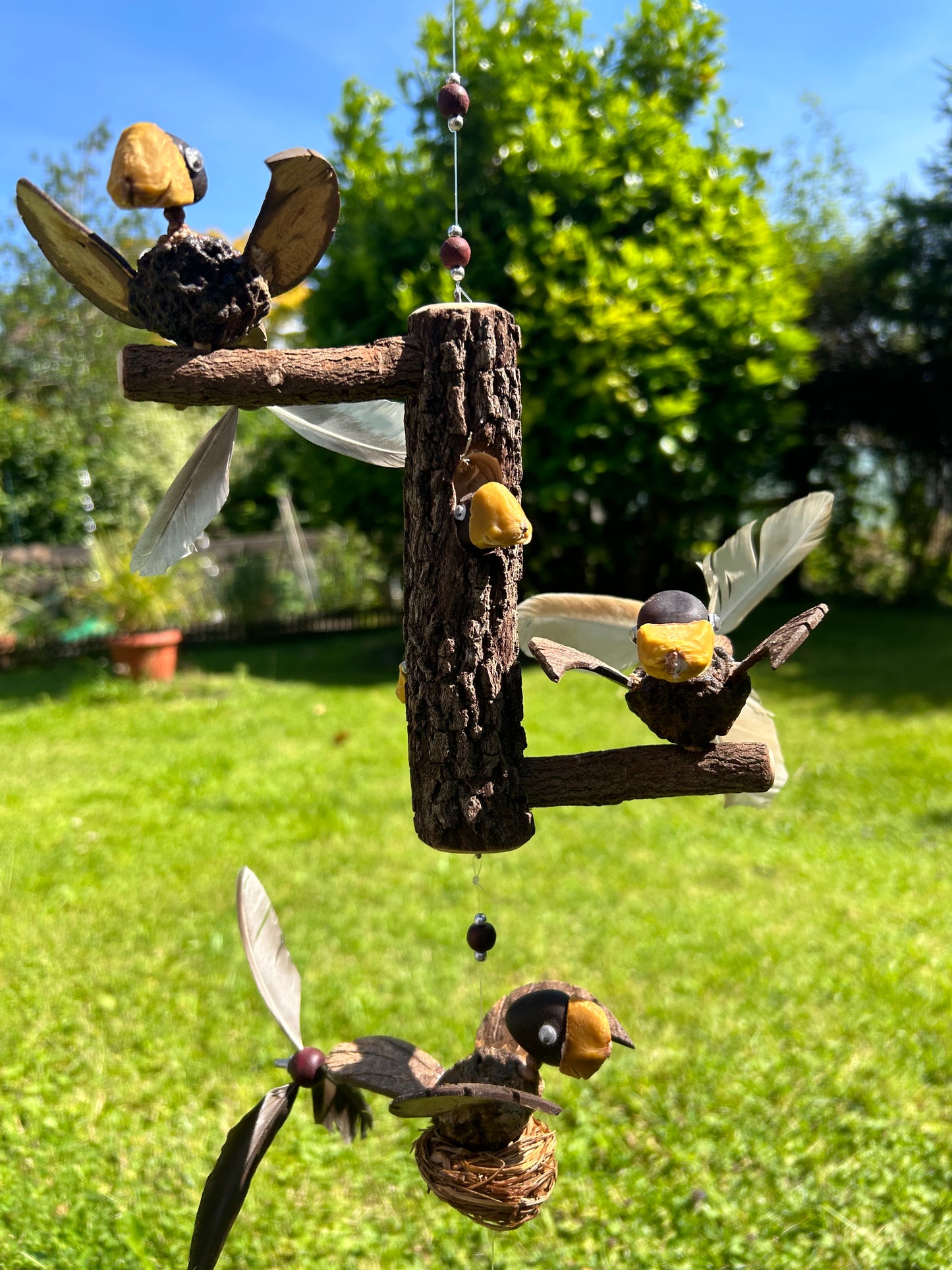 Windspiel Vogel auf Baumstamm