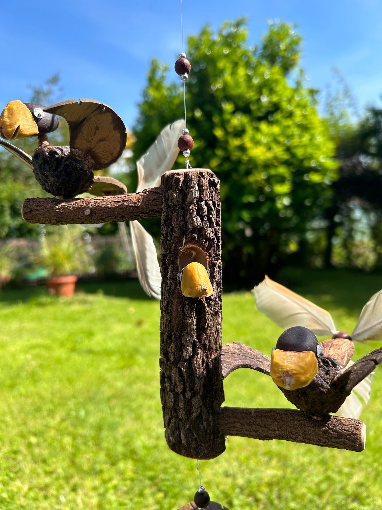 Windspiel Vogel auf Baumstamm