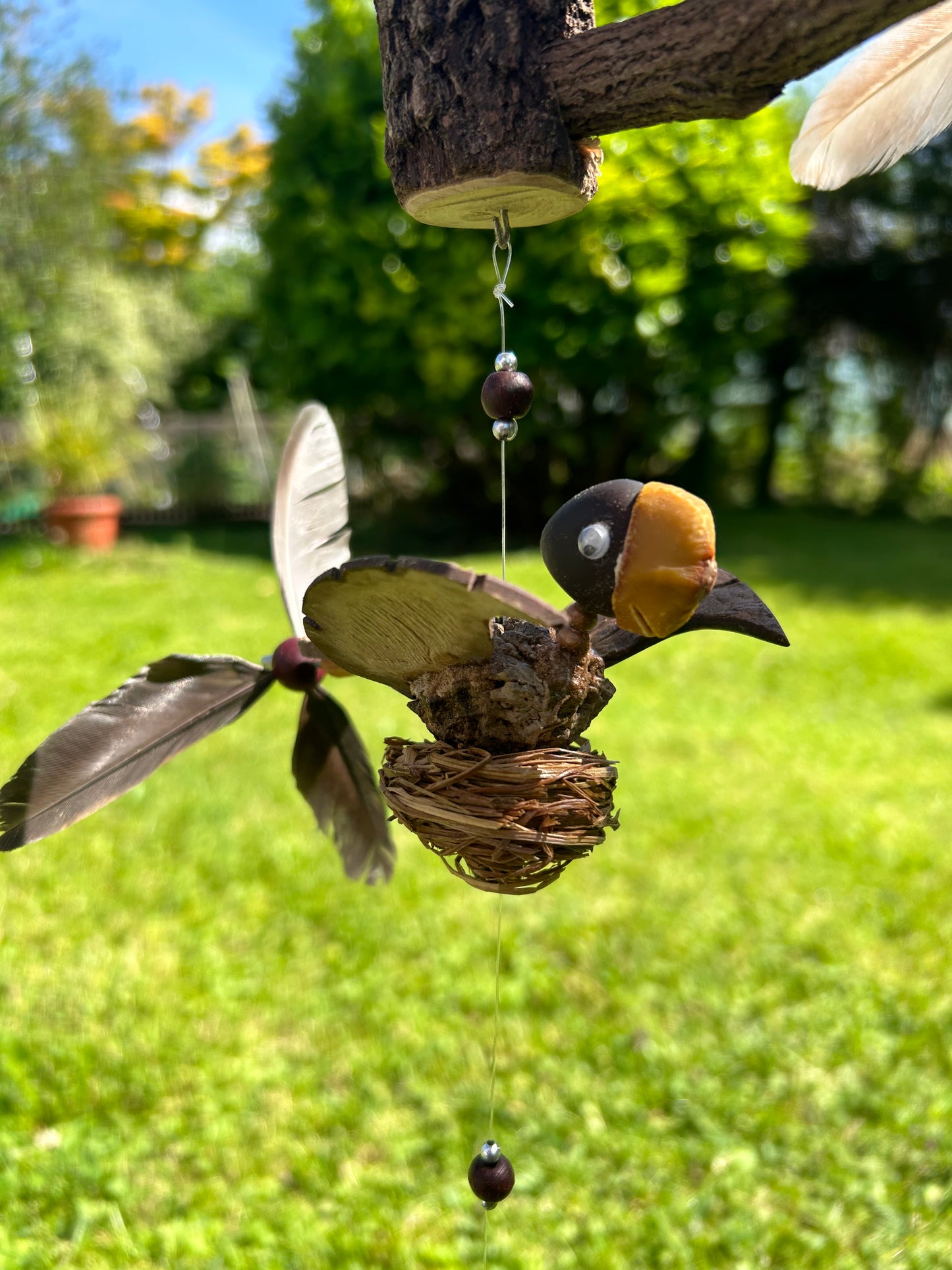 Windspiel Vogel auf Baumstamm