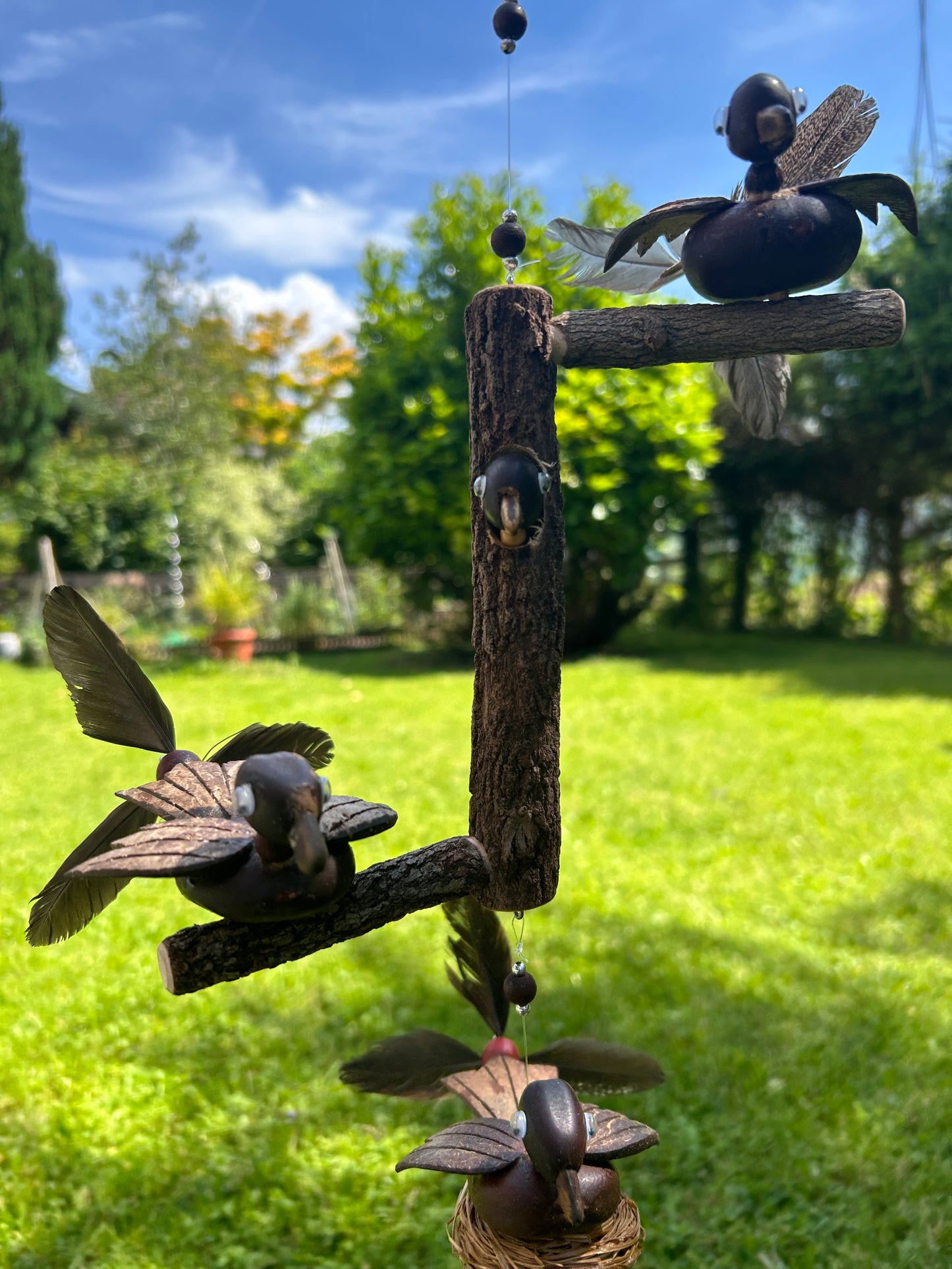 Windspiel Ente auf Baumstamm