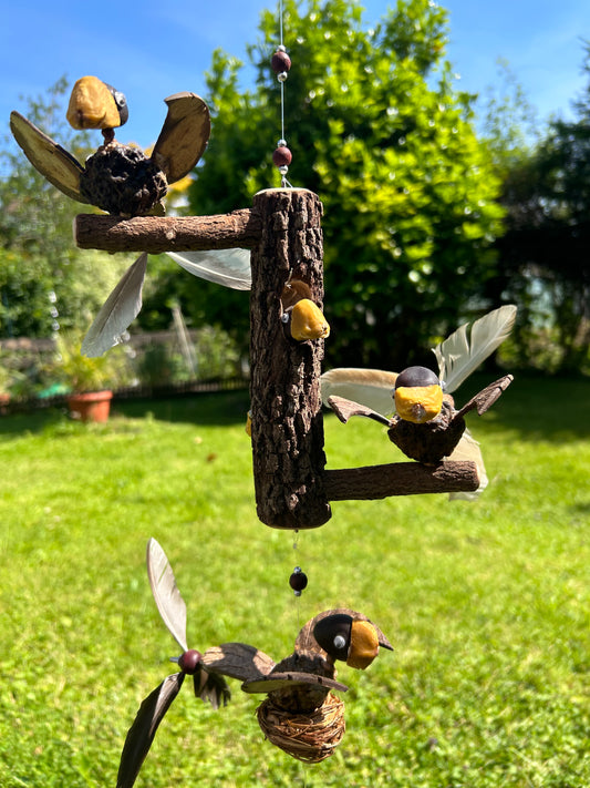 Windspiel Vogel auf Baumstamm